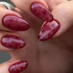 Бордовый желейный маникюр на миндальных ногтях: полупрозрачный глянцевый лак с тонким цветочным узором