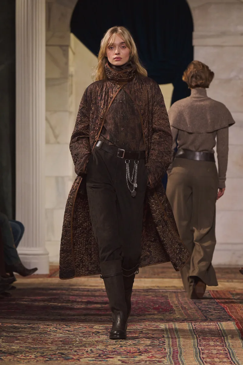 Длинное коричневое пальто с узором поверх темных брюк и сапог, Ralph Lauren
