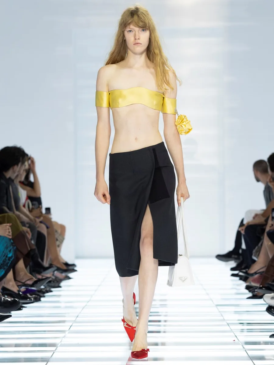 Черная юбка с запахом и разрезом и красные лодочки с острым носом, Prada весна-лето 2027
